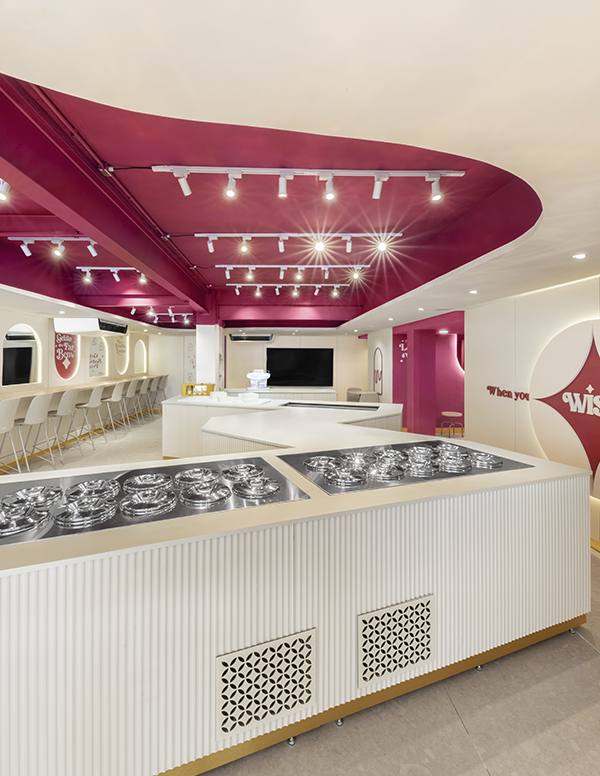 Interior da gelateria saudável The Wish Factory com design de interiores que integra branding e arquitetura comercial em tons de vinho e dourado.